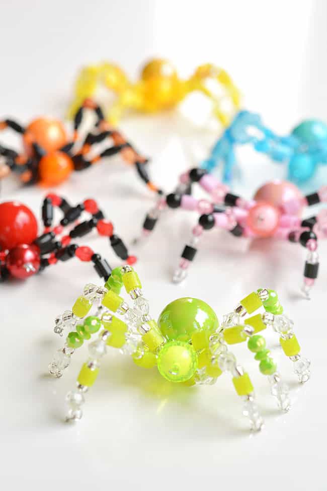 Green beaded spider in front of five others