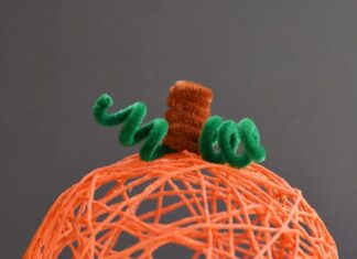 DIY Yarn Pumpkins with Balloons: Step-by-Step Guide Orange yarn pumpkin on a dark background