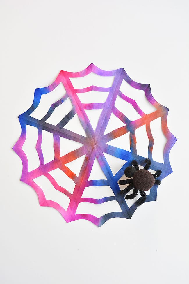 These coffee filter spider webs are SO EASY to make and they look AWESOME! The pipe cleaner and pom pom spider is so simple, but it really makes this Halloween decoration look amazing! This is such a fun Halloween craft for kids and a simple way to make some spooky Halloween decor!