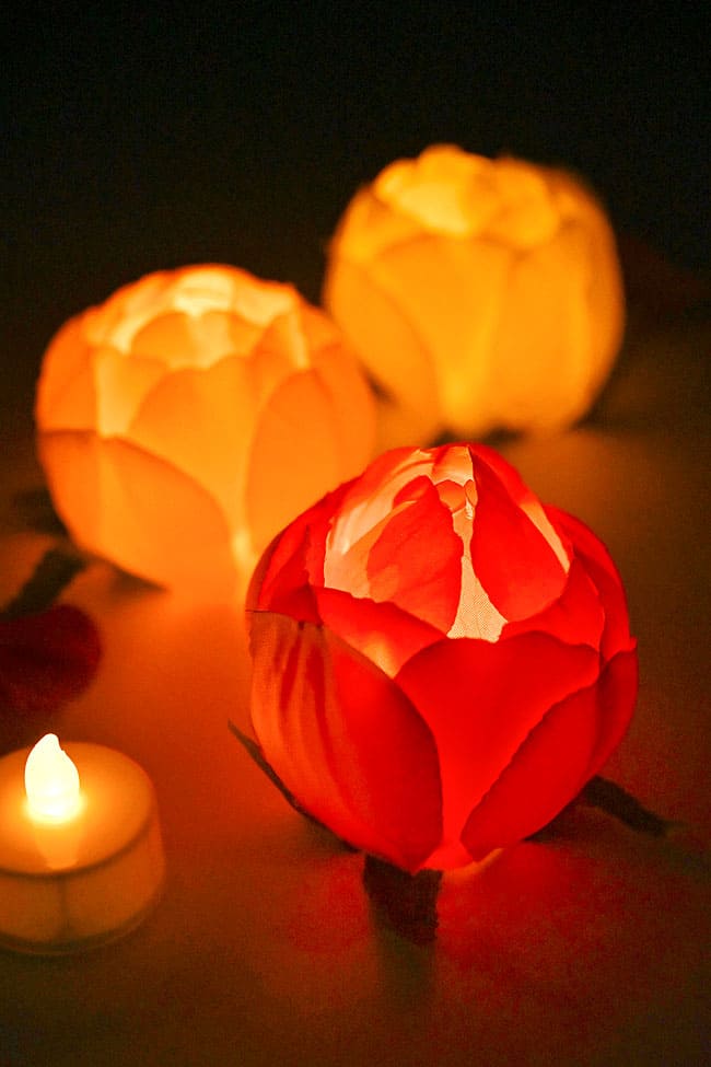 Flower covered candles lit up and glowing in a dark room