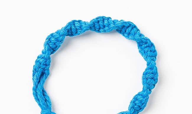 Macrame Bracelet Closeup of a blue macrame bracelet made with a half knot spiral