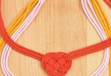 DIY Macrame Necklace Three Celtic heart macrame necklaces on a wooden background