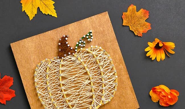 Pumpkin String Art Pumpkin string art signs surrounded by fall leaves and flowers