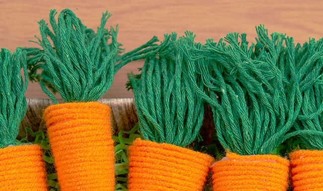 DIY Yarn Carrot Craft: Easy Easter Project Yarn wrapped carrots in a basket with Easter grass