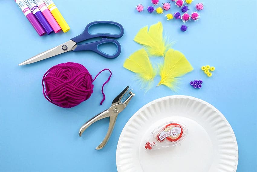 Dreamcatcher supplies laying on a blue background