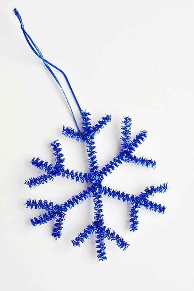 These snowflake pipe cleaner ornaments are so COOL and they're really simple to make. You only need 2 pipe cleaners! This is such an easy Christmas craft that you can make in less than 5 minutes using dollar store supplies. Such a fun Christmas activity for kids and a great way to make homemade Christmas ornaments! Be sure to check out the other 5 tutorials in this series for more pipe cleaner ornaments that go along with this frosty snowflake!
