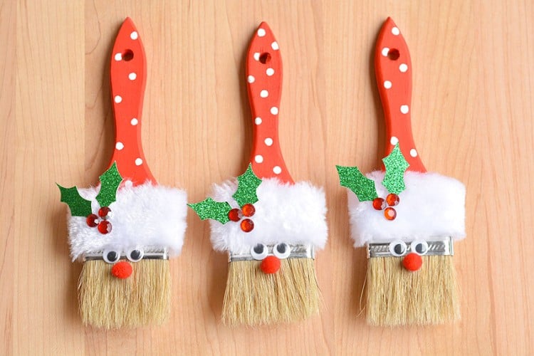 Three paint brushes decorated as Santa Claus