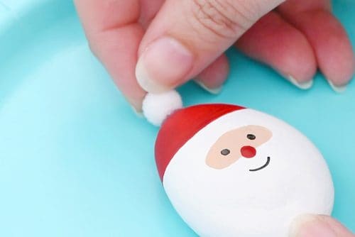 Adding pom pom to Santa rock hat