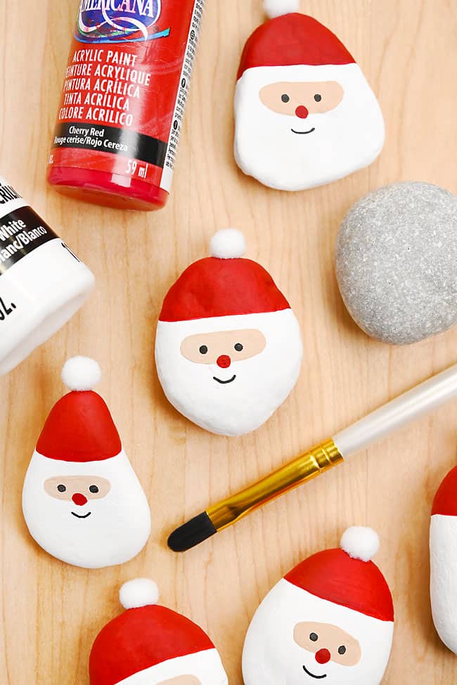 Santa painted rocks with paint bottles and paint brush