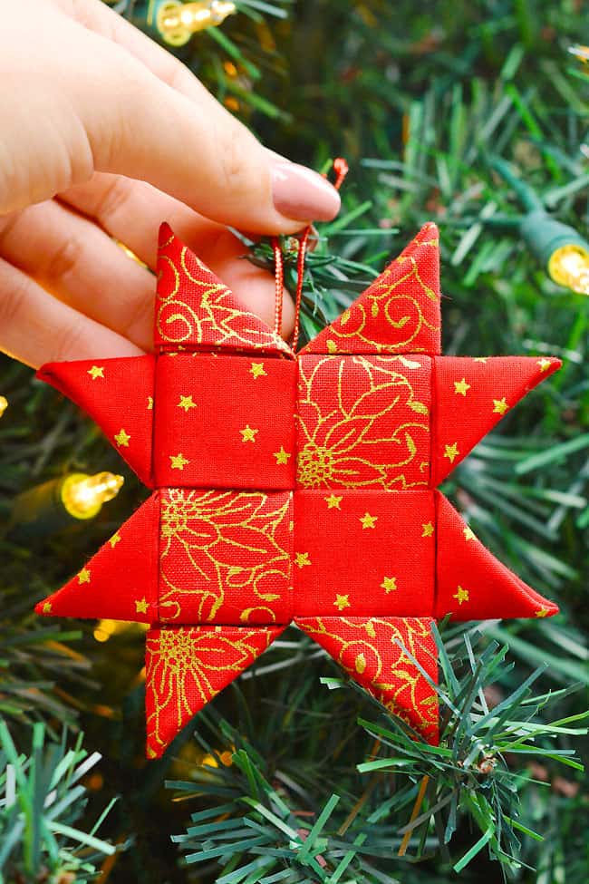 Scandinavian star ornament in front of a Christmas tree