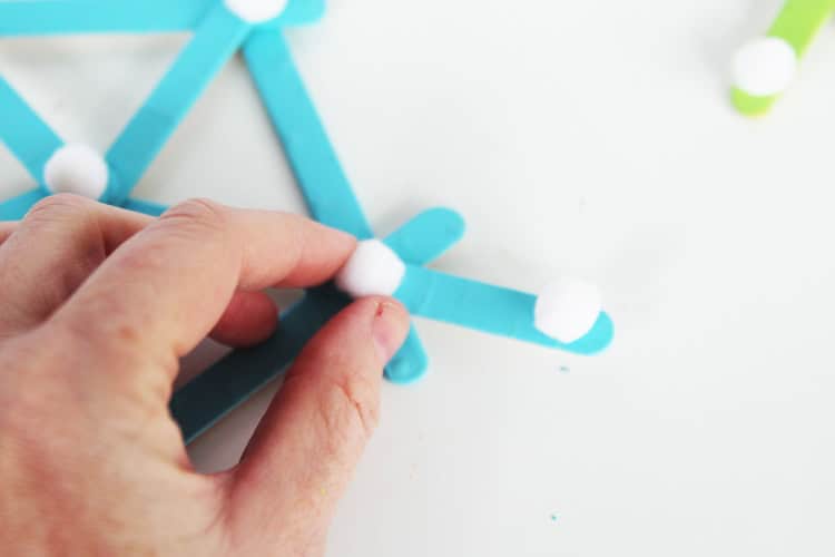 These DIY popsicle stick snowflakes are SO easy to make and look so bright and cheerful!