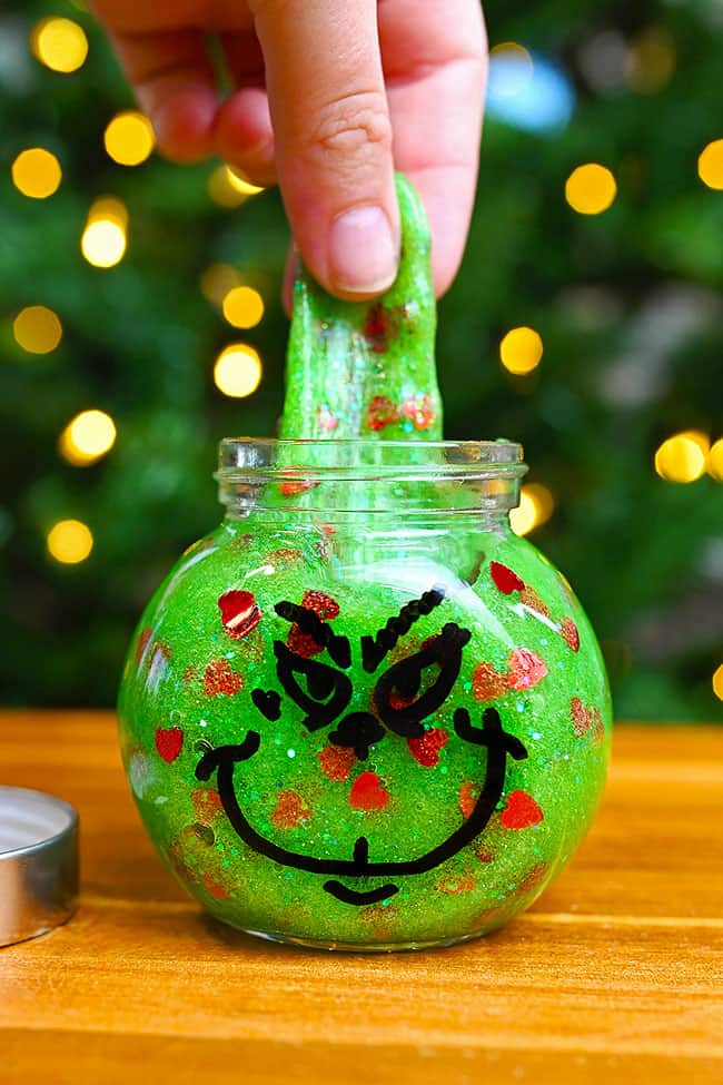 Grinch Slime Pulling stretchy Grinch slime out of the jar