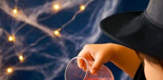 Fizzy Witch Cauldron – Fun Bubbling Brew Experiment for Kids Pouring colored vinegar into a baking soda filled witch cauldron
