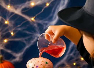 Fizzy Witch Cauldron – Fun Bubbling Brew Experiment for Kids Pouring colored vinegar into a baking soda filled witch cauldron