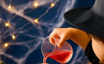 Fizzy Witch Cauldron – Fun Bubbling Brew Experiment for Kids Pouring colored vinegar into a baking soda filled witch cauldron