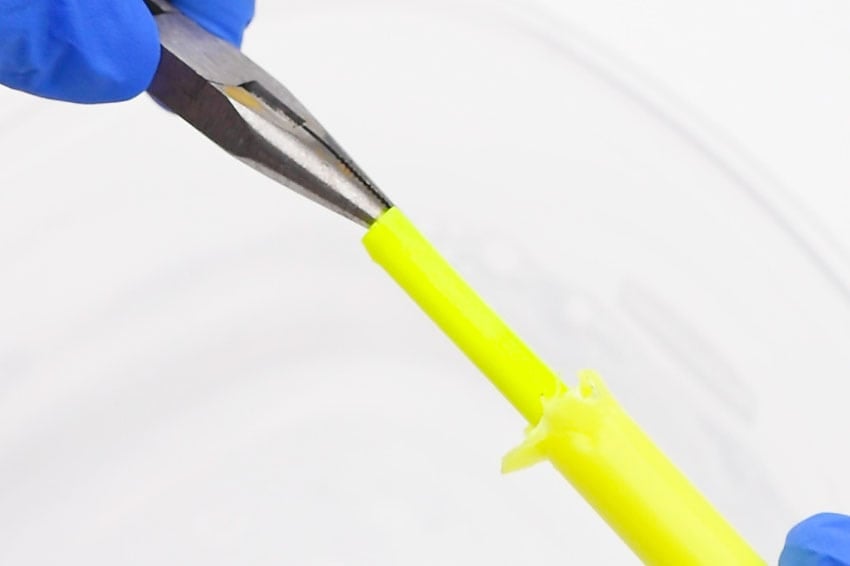 glow-in-the-dark-bubbles-3 A person in blue gloves holding a yellow plastic tube.