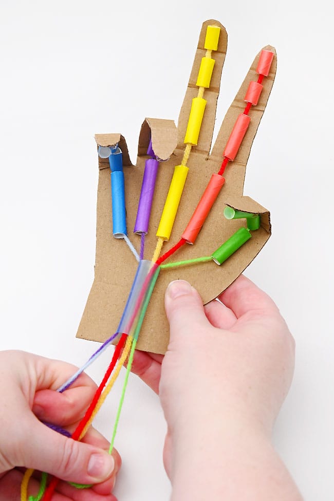 Using a cardboard robotic hand to give a peace sign