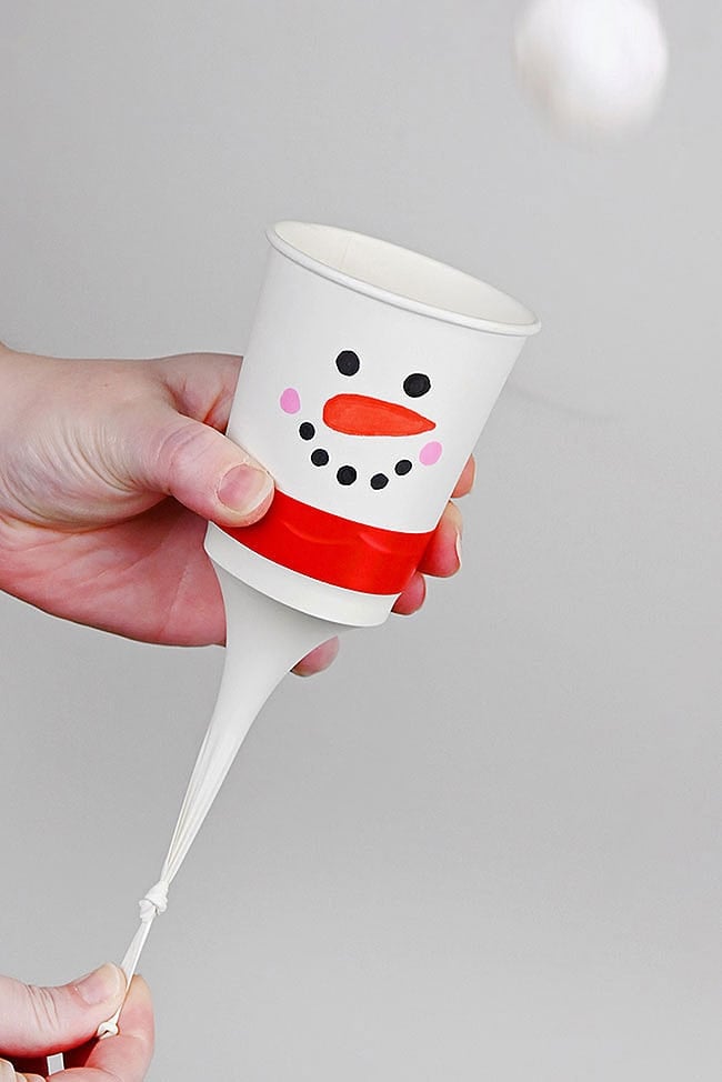 Playing with a snowman pom pom launcher